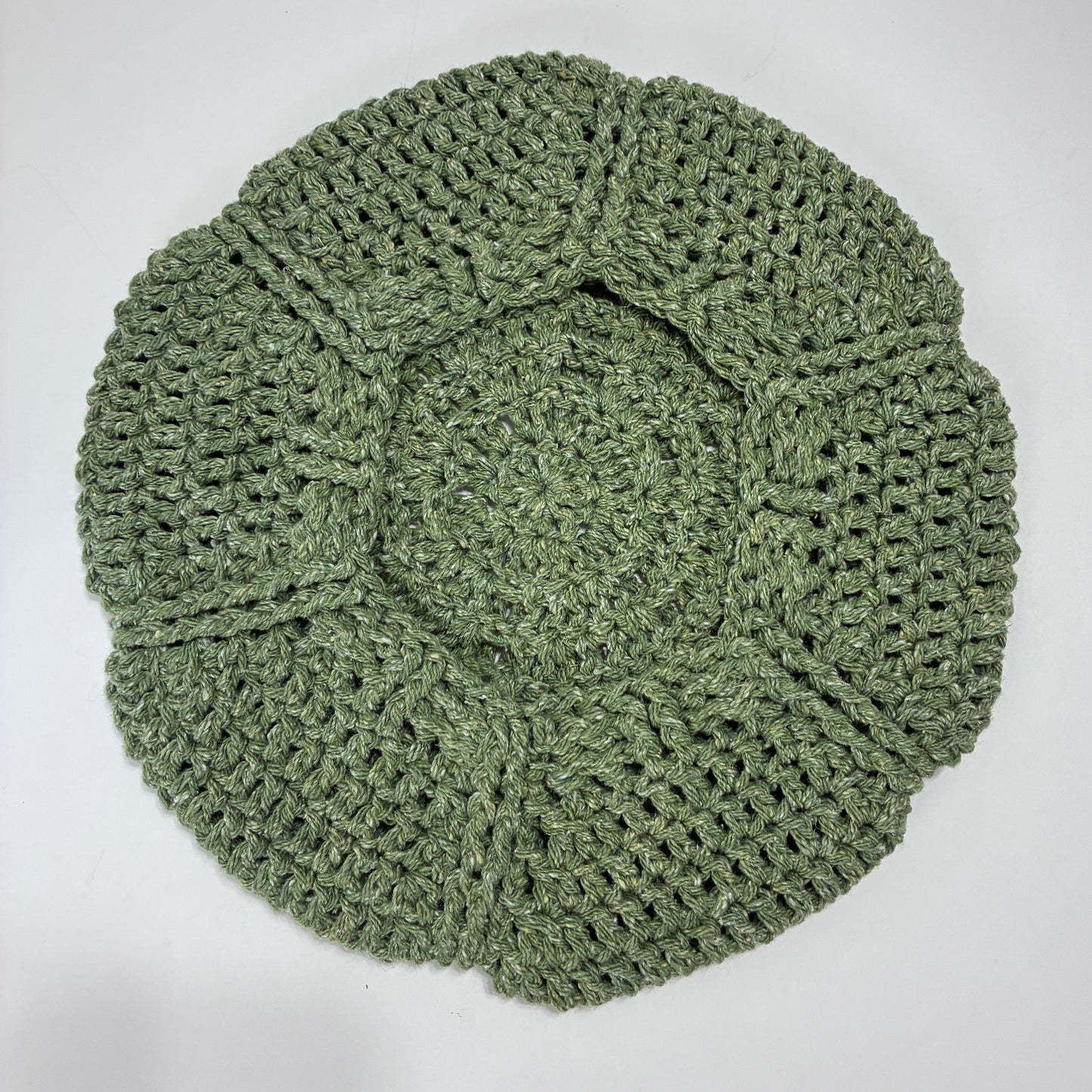 Green crocheted beret on a white background