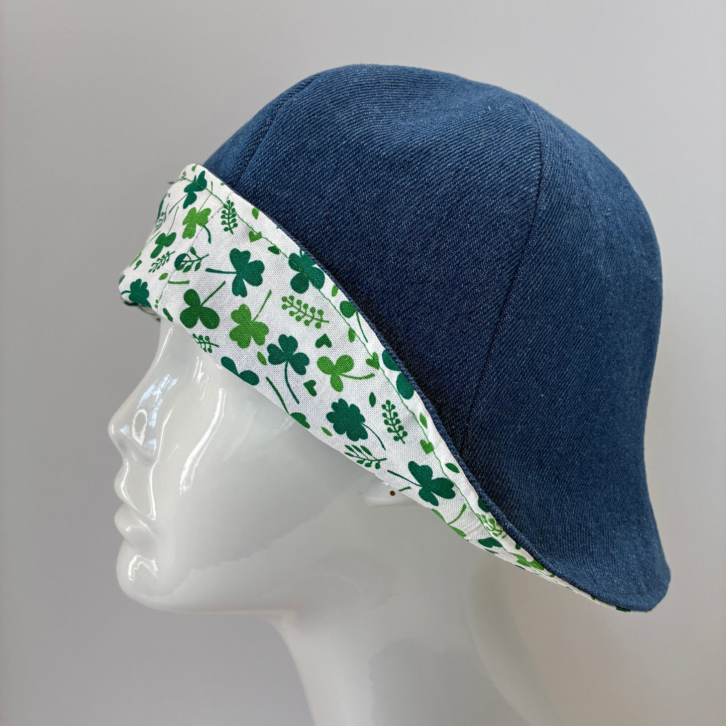 Blue denim hat with green shamrock pattern

