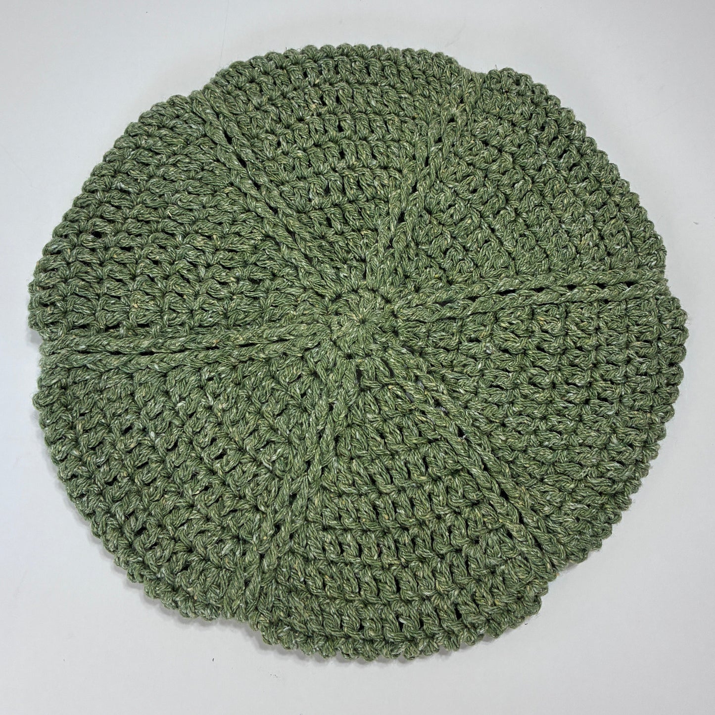 Green crocheted beret on a white background