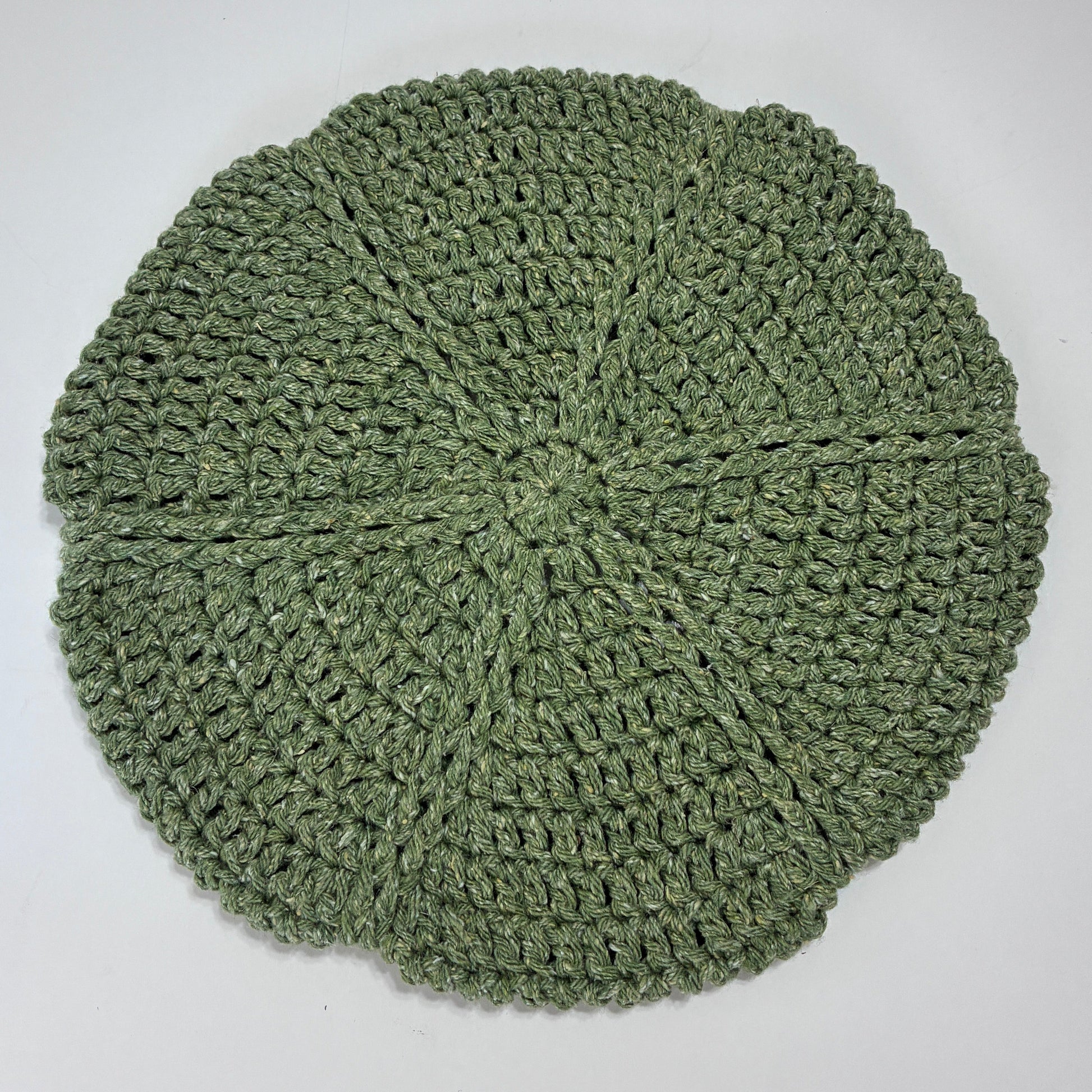 Green crocheted beret on a white background