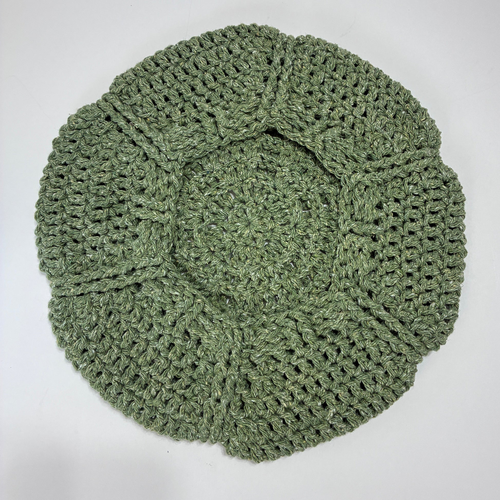 Green crocheted beret on a white background